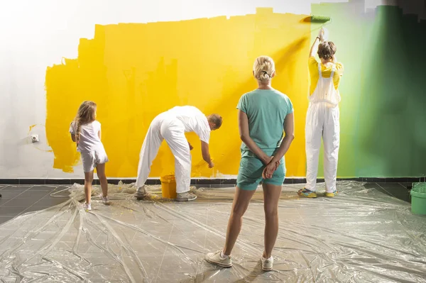 Feliz Familia Renovando Casa Están Pintando Una Pared Juntos —  Fotos de Stock