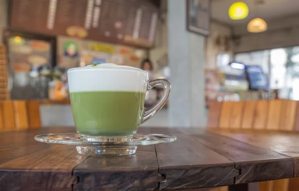 Eine Tasse grünen Tee Matcha Latte mit Untertasse. Holz Tisch Backgrou — Stockfoto