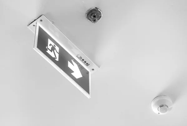 Segnale di uscita di emergenza, luce cubo sul soffitto, concetto di monochro — Foto Stock