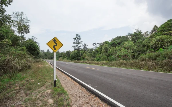 Bochtige weg teken naar de berg in landelijk gebied — Stockfoto