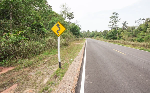 Bochtige weg teken naar de berg in landelijk gebied — Stockfoto