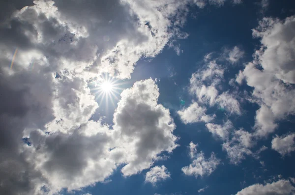 Пасмурное голубое небо и солнце — стоковое фото