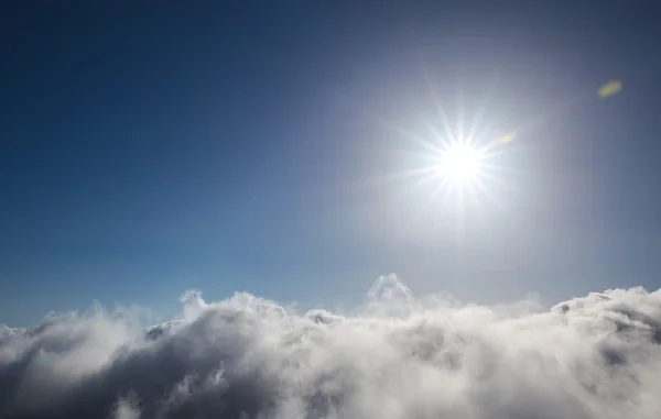 Пасмурное голубое небо и солнце — стоковое фото