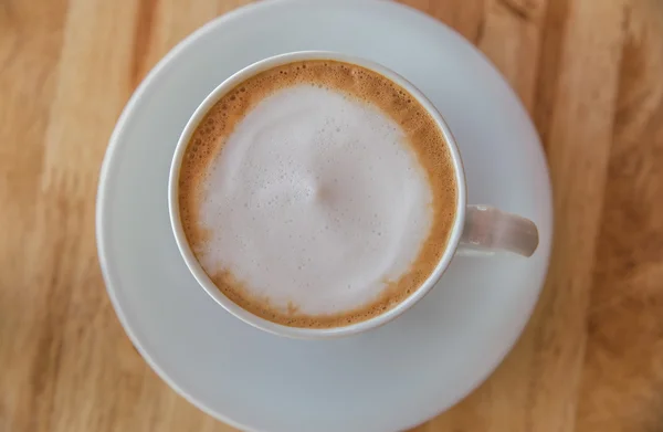 Uma xícara de café com uma xícara branca em fundo de madeira — Fotografia de Stock