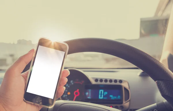 Handy im Auto nutzen - bei defokussiertem Stadtverkehr. — Stockfoto