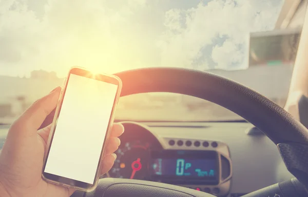 Handy im Auto nutzen - bei defokussiertem Stadtverkehr. — Stockfoto