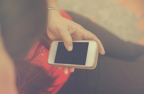 Kvinnor hand använda smart telefon. Vintage filter. — Stockfoto