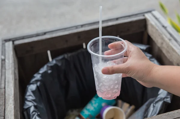 Closeup hand holding piece of garbage in trash can — Stock Photo, Image