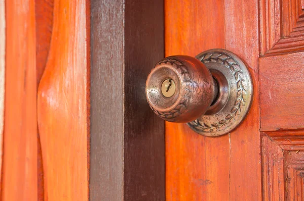 Старинная дверная ручка на натуральной деревянной двери — стоковое фото