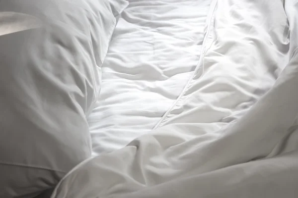 Rommelig witte bed en het licht schijnt, in de ochtend — Stockfoto