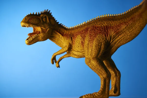 Dinossauro em fundo azul — Fotografia de Stock