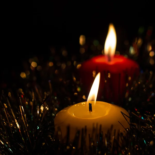 Velas de Natal brilhantes com uma guirlanda cintilante no fundo preto — Fotografia de Stock