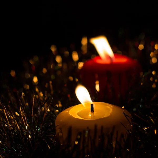 明亮的圣诞蜡烛与黑色背景上闪闪发光的花环 — 图库照片
