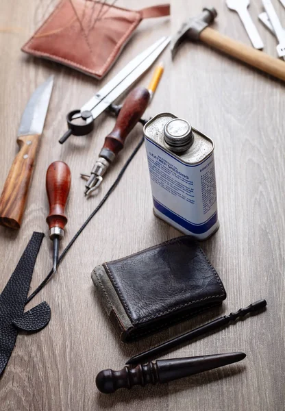 Concept of handcrafted leather goods. The moment of rubbing the side of the wallet. Handcrafted tools. Genuine leather design