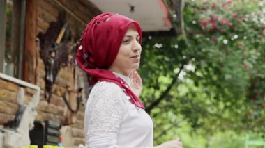  İnsanları geleneksel bir çay evine davet eden bir Türk kızı. Cumalikizik, Bursa, Türkiye