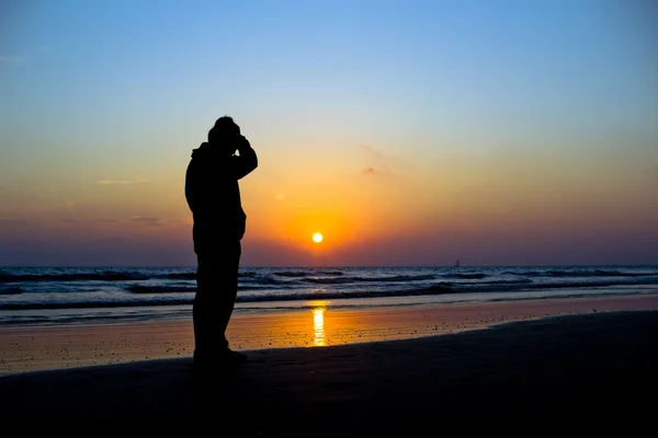 Sylwetki przed sunse oceanu żywy człowiek — Zdjęcie stockowe
