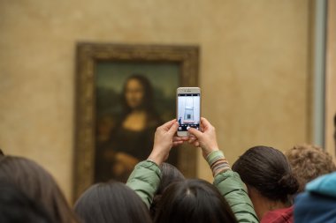 PARIS, FRANCE - APRIL 30, 2016 - Mona Lisa painting Louvre hall crowded of tourist