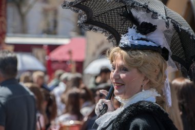 PARIS, FRANCE - MAY 1 2016 - Old dressed woman in Montmartre crowded of people for sunday sunny day
