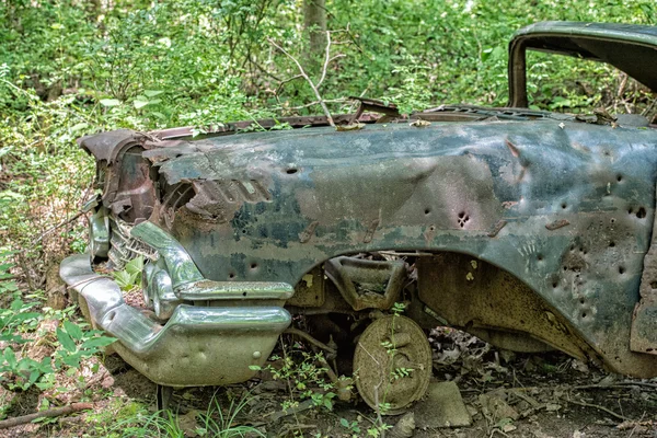Старый ржавый автомобиль брошен в лесу с пулевыми отверстиями — стоковое фото