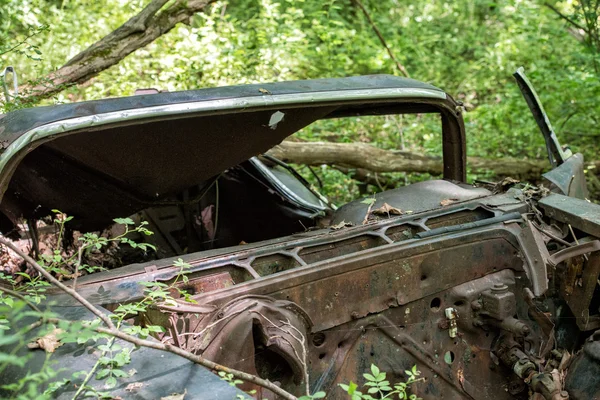 Vecchia auto arrugginita abbandonata nella foresta con fori di proiettile — Foto Stock