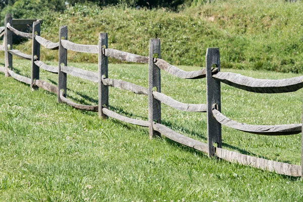 Stare drewniane ogrodzenie na tle zielonej trawie — Zdjęcie stockowe