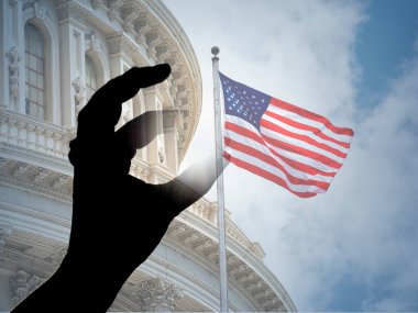 Başkent kongresi Washington DC 'de Amerikan bayrağını yakalayan parmaklar.