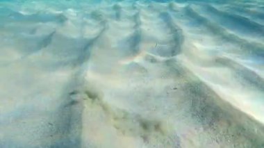 Turkuaz gölünde şnorkelle yüzerken suyun altında kum var.