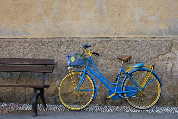 Bicicleta vintage perto de banco de madeira — Fotografia de Stock