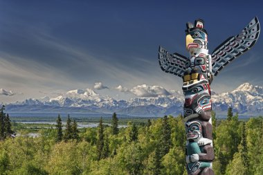 A totem wood pole in mountain background clipart