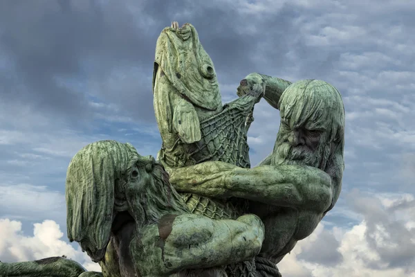 Силуэт медной статуи рыбака-титана — стоковое фото