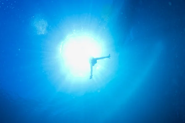 Hintergrundbeleuchtung Taucher unter Wasser — Stockfoto