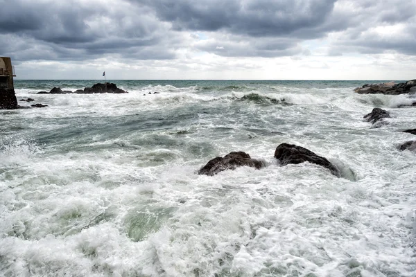 Zee in tempest op rotsen oever — Stockfoto