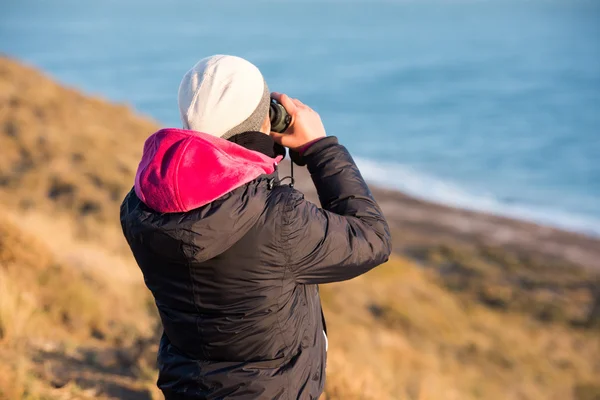 Girl looking sea with binoculars — Stock Photo, Image