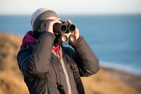 Girl looking sea with binoculars — Stock Photo, Image