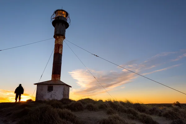 Homem fora do farol da patagônia ao pôr do sol — Fotografia de Stock