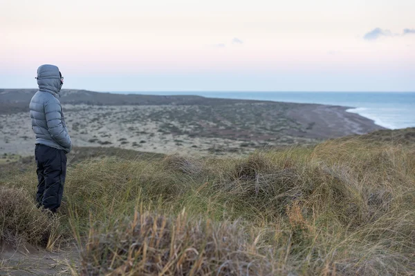 Mann sieht rosa Sonnenaufgang am Strand von Patagonien — Stockfoto