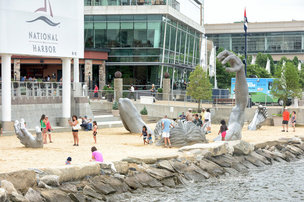 OXON HILL, MD - JUNE 19 2015 Awakening Sculpture at National Harbor on August 24, 2013 at Oxon Hill, MD USA. A famous 70-foot statue of a giant embedded in the earth created by J. Seward Johnson Jr.