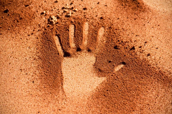 红壤手形状像原住民艺术风格的沙滩上 — 图库照片