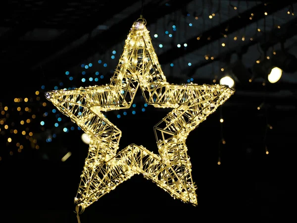 Altın yıldızlı Noel ağacı ışıkları yanıp sönüyor.