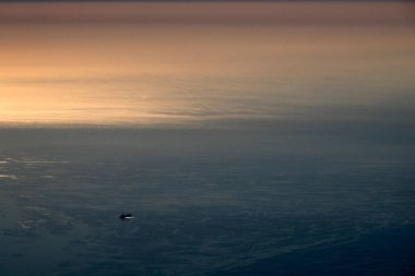 Gün batımından itibaren uçak penceresinden büyük bir gemi konteynırı görüntüsü