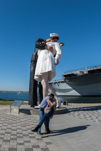 SAN DIEGO, USA - NOVEMBER 14, 2015 - People taking a selfie at sailor and nurse while kissing statue san diego