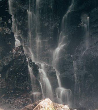 Siyah taştan bir şelaleye uzun süre maruz kalmış. Orta Meksika 'nın ormanlarından birinde yapılmış minimalist bir manzara..