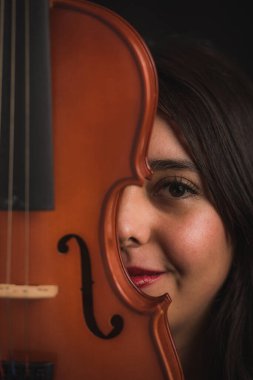 Kemanla bölünmüş genç bir İspanyol kadının yüzü, yüzünde tebessümle enstrümanın tahtasını teniyle okşarken bir gülümseme belirir. 