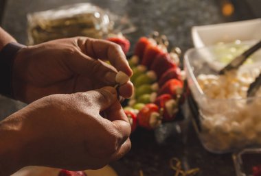 Aşçı mutfakta meyve, çilek, üzüm ve bonbon pankartları topluyor. 