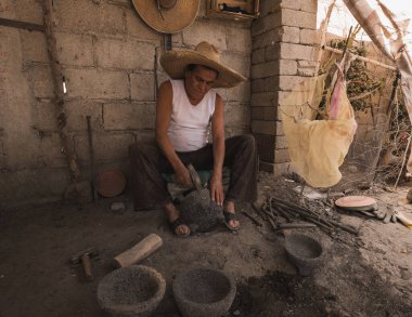 Atölyesinde çalışan bir zanaatkar, Molcajetes yapmak için taşı oyuyor. Sosları hazırlamak için Meksika 'nın geleneksel acı biber, avokado ya da domates hazırlıyor.. 