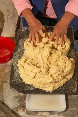 Yerli Meksikalı kadın mutfakta el yapımı tortilla hazırlıyor, totrtillalar çeşitli geleneksel Meksika yemeklerinde kullanılıyor..