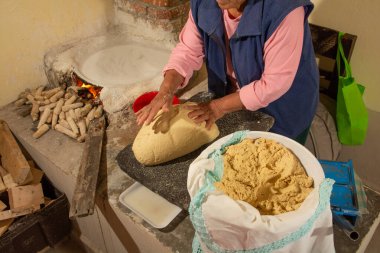 Yerli Meksikalı kadın mutfakta el yapımı tortilla hazırlıyor, totrtillalar çeşitli geleneksel Meksika yemeklerinde kullanılıyor..