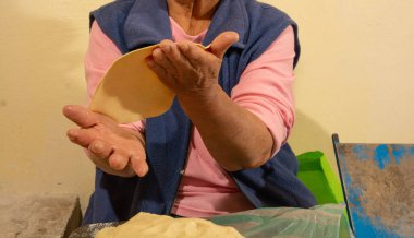 Yerli Meksikalı kadın mutfakta el yapımı tortilla hazırlıyor, totrtillalar çeşitli geleneksel Meksika yemeklerinde kullanılıyor..