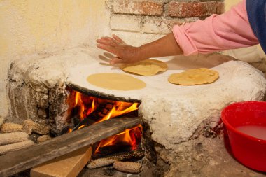 Yerli Meksikalı kadın mutfakta el yapımı tortilla hazırlıyor, totrtillalar çeşitli geleneksel Meksika yemeklerinde kullanılıyor..