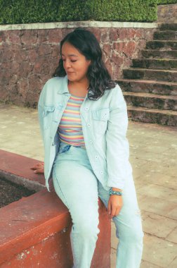  Kot pantolon giyen Latin kız ufka bakıyor, çok düşünceli..